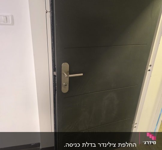 דלת שחורה פתוחה עם ידית מתכת